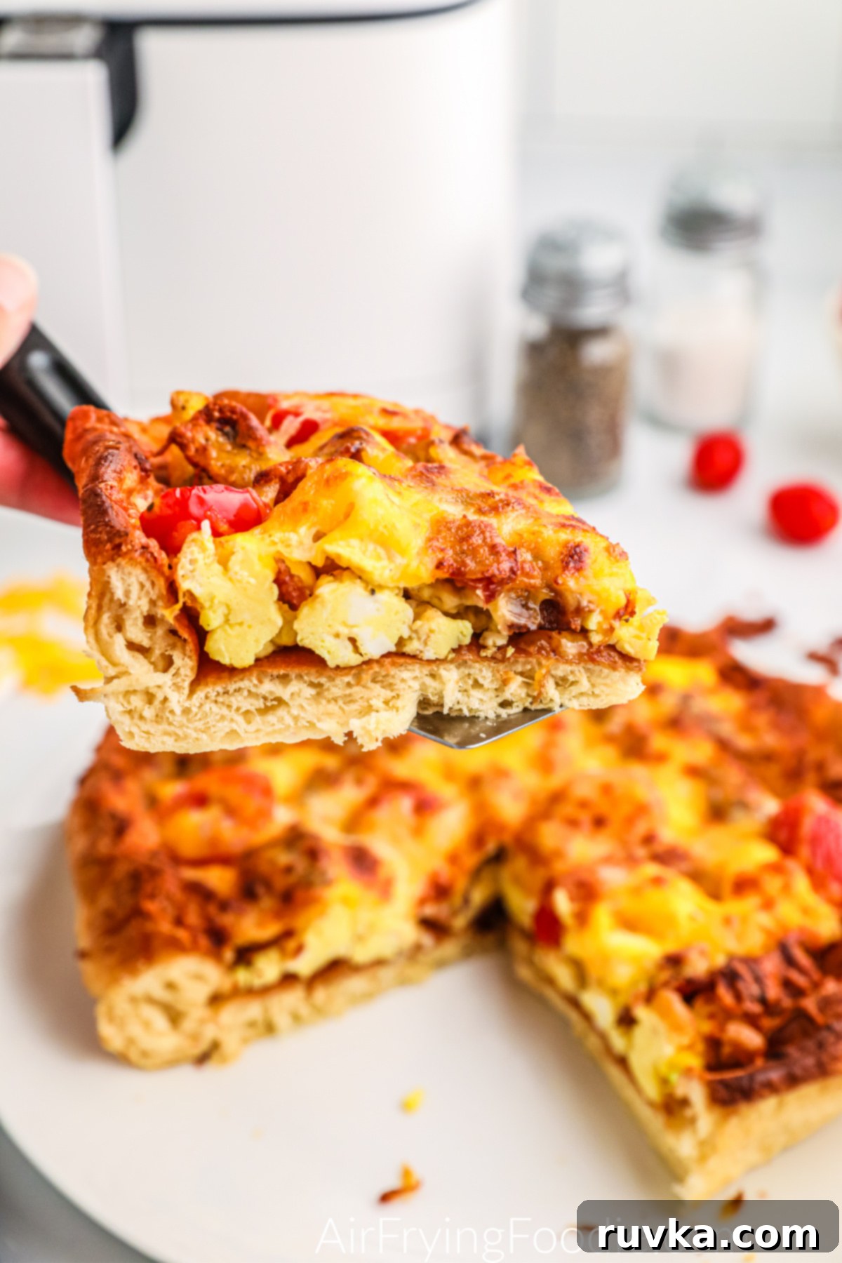 Crispy Air Fryer Breakfast Pizza 2 Slice of breakfast pizza made in the air fryer on a spatula.