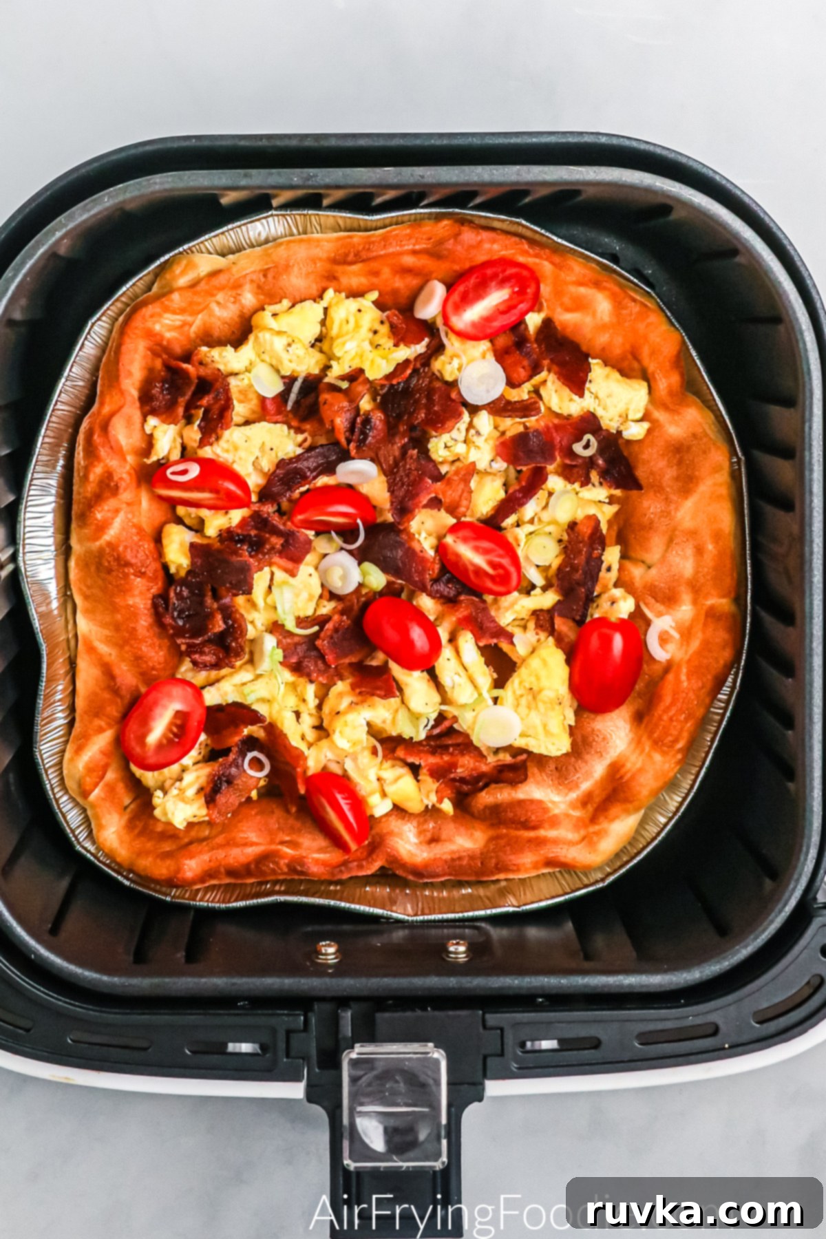 Crispy Air Fryer Breakfast Pizza 4 Breakfast pizza in the basket of the air fryer.