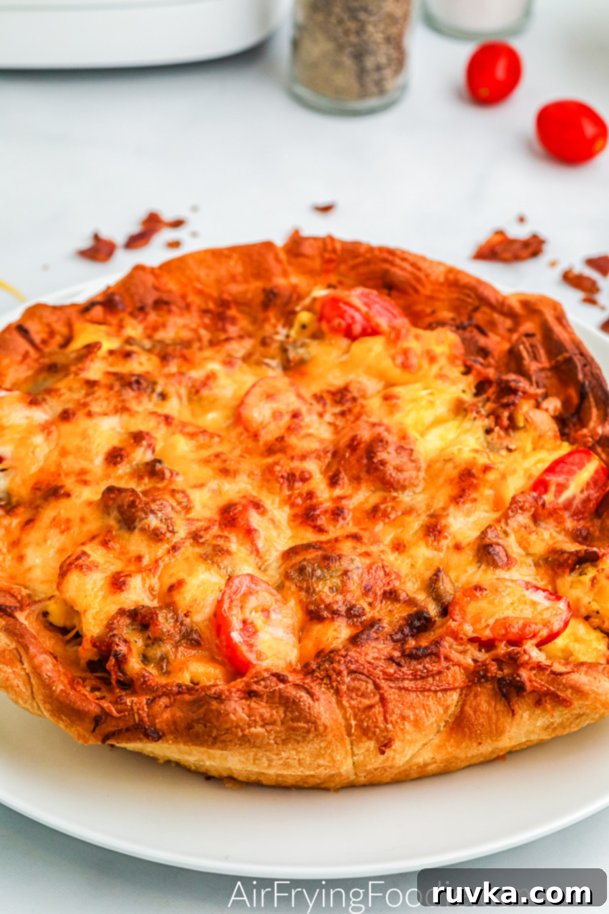 Crispy Air Fryer Breakfast Pizza 6 Breakfast pizza on a white plate ready to slice and serve.