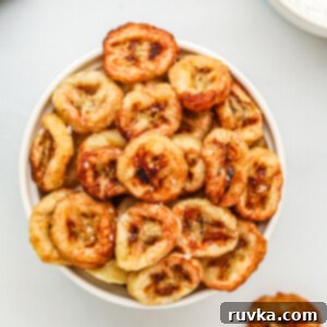 Crispy Air Fryer Banana Chips 10 Banana chips made in the air fryer, served in a whote bowl with a sprinkling of kosher salt on top.