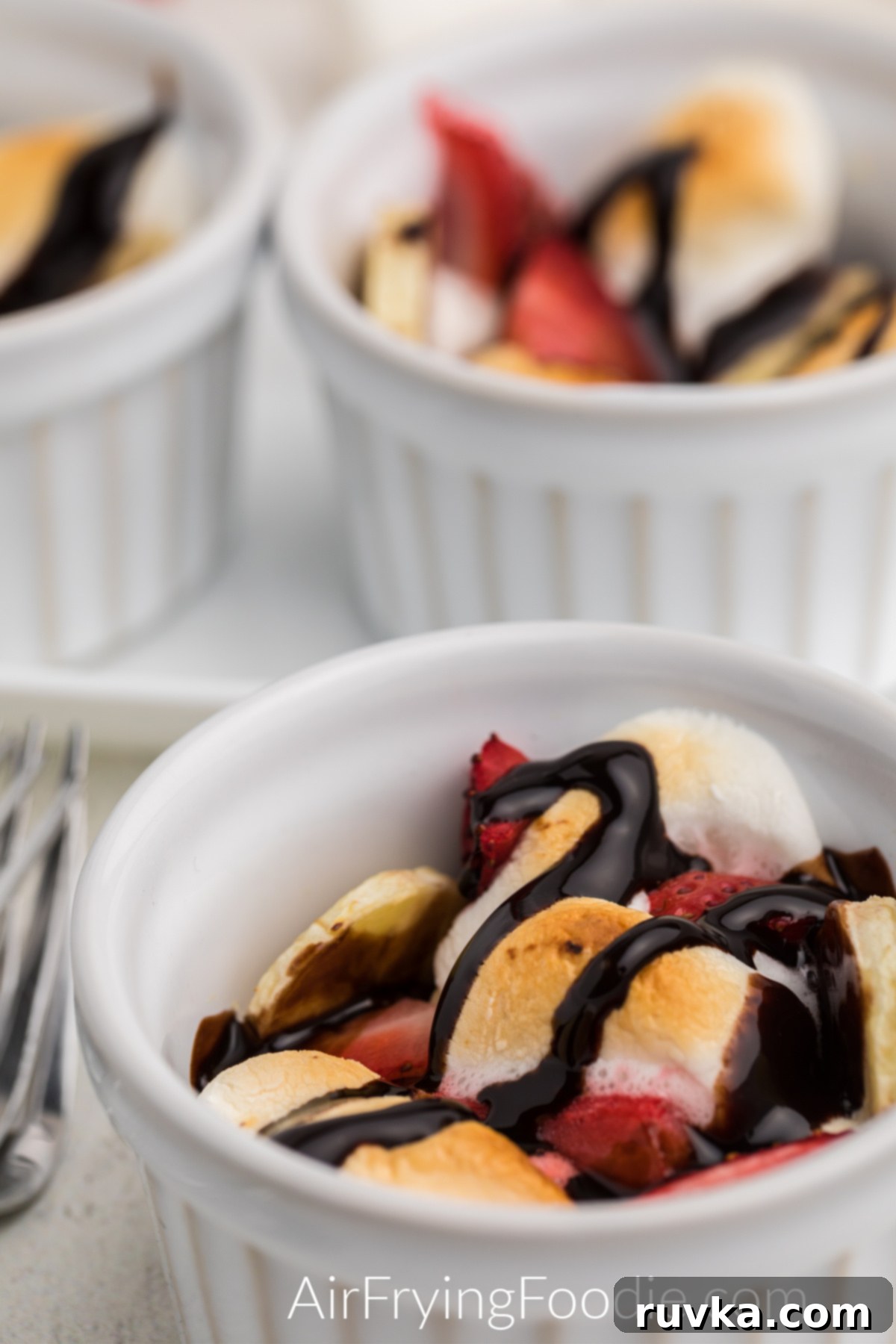Delicious Air Fryer Strawberry Banana Bowl 8 Air fried strawberry banana bowls with chocolate topping, displayed on a table.