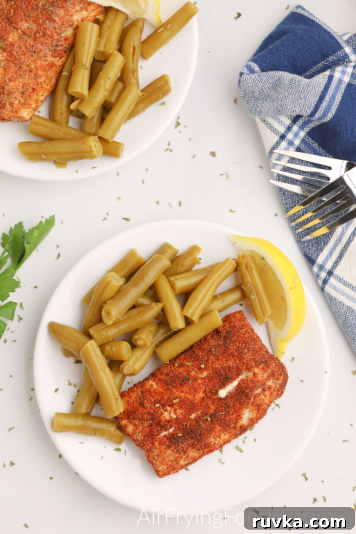 Quick and Delicious Air Fryer Mahi Mahi 2 Overhead shot of Air Fryer Mahi Mahi on a plate with green beans and a lemon slice.