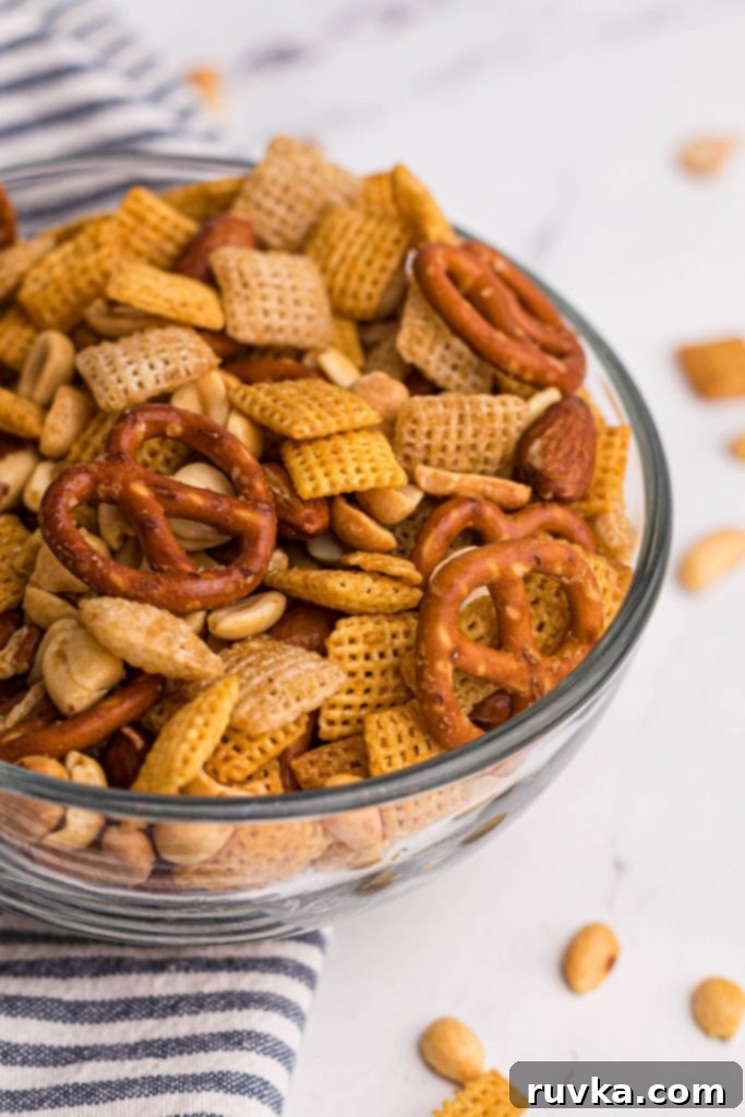 Easy Air Fryer Chex Mix 8 Air fried chex mix in a clear bowl after being cooked with seasonings.