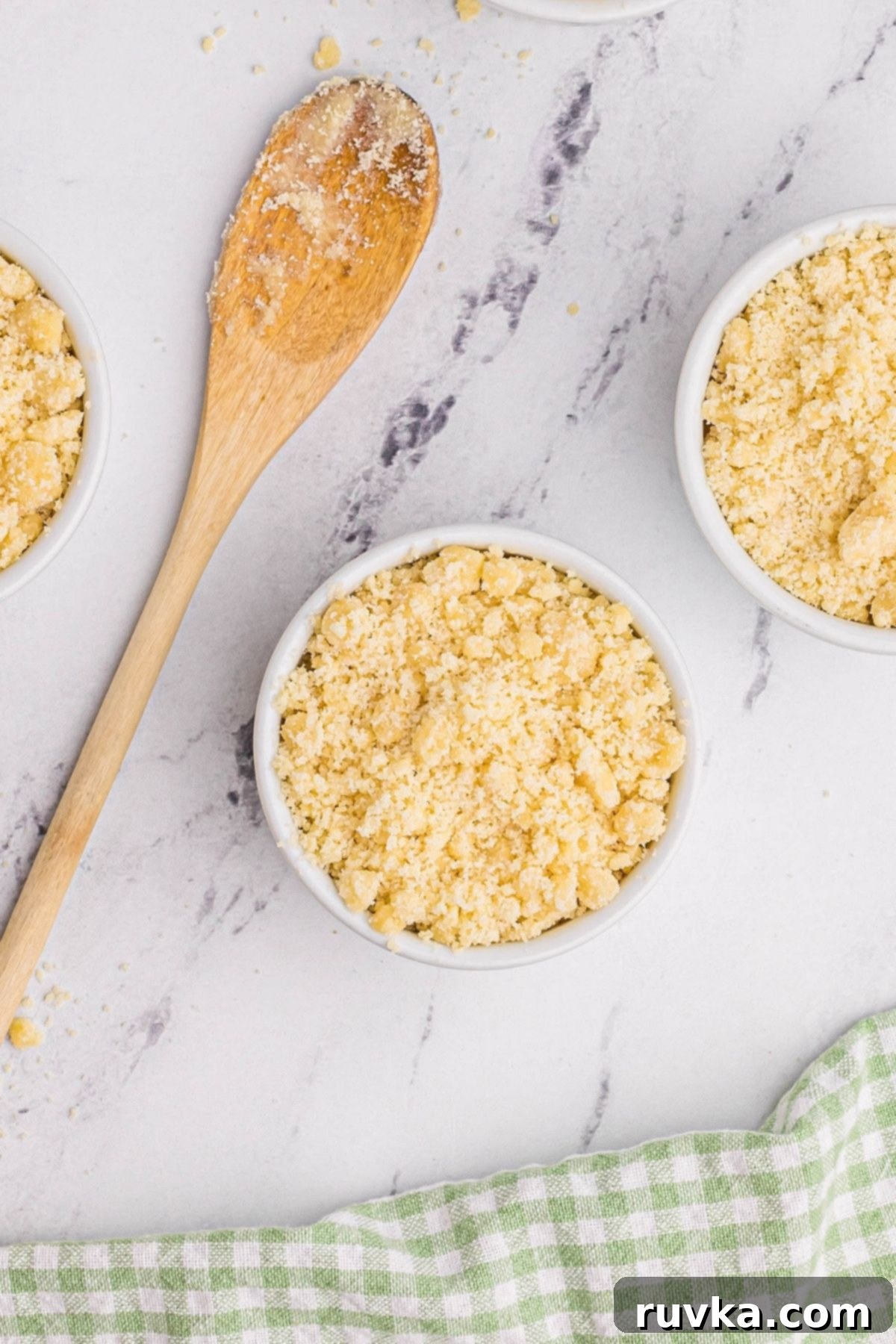 Easy Air Fryer Peach Cobbler 6 White ramekins filled with peaches topped with coating