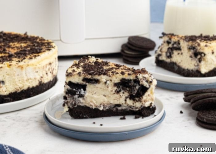 Unlock Your Air Fryer 10 Must-Know Answers 2 Air Fryer Oreo Cheesecake, cut and sliced on a plate in front of an air fryer with Oreo's spread around it.