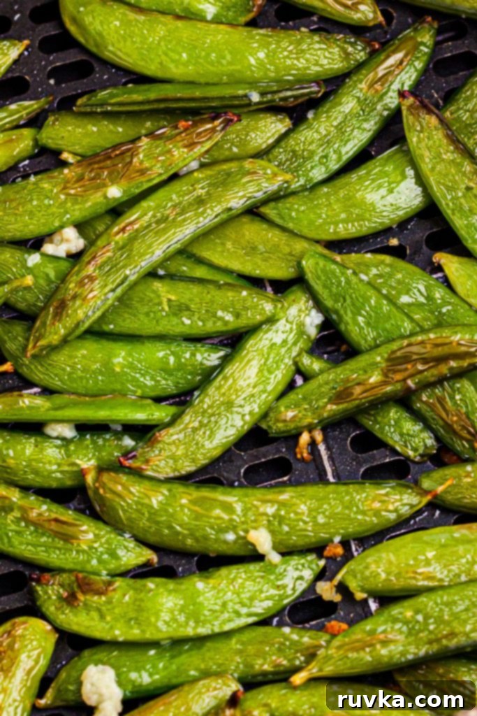 Crispy Air-Fried Snap Peas 9 Close-up of vibrant green, juicy snap peas seasoned with garlic and sesame oil, ready for air frying.