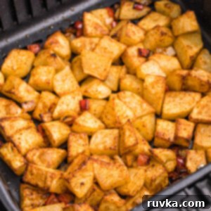 Crispy Air Fryer Home Fries 12 cooked home fries in the basket of the air fryer.