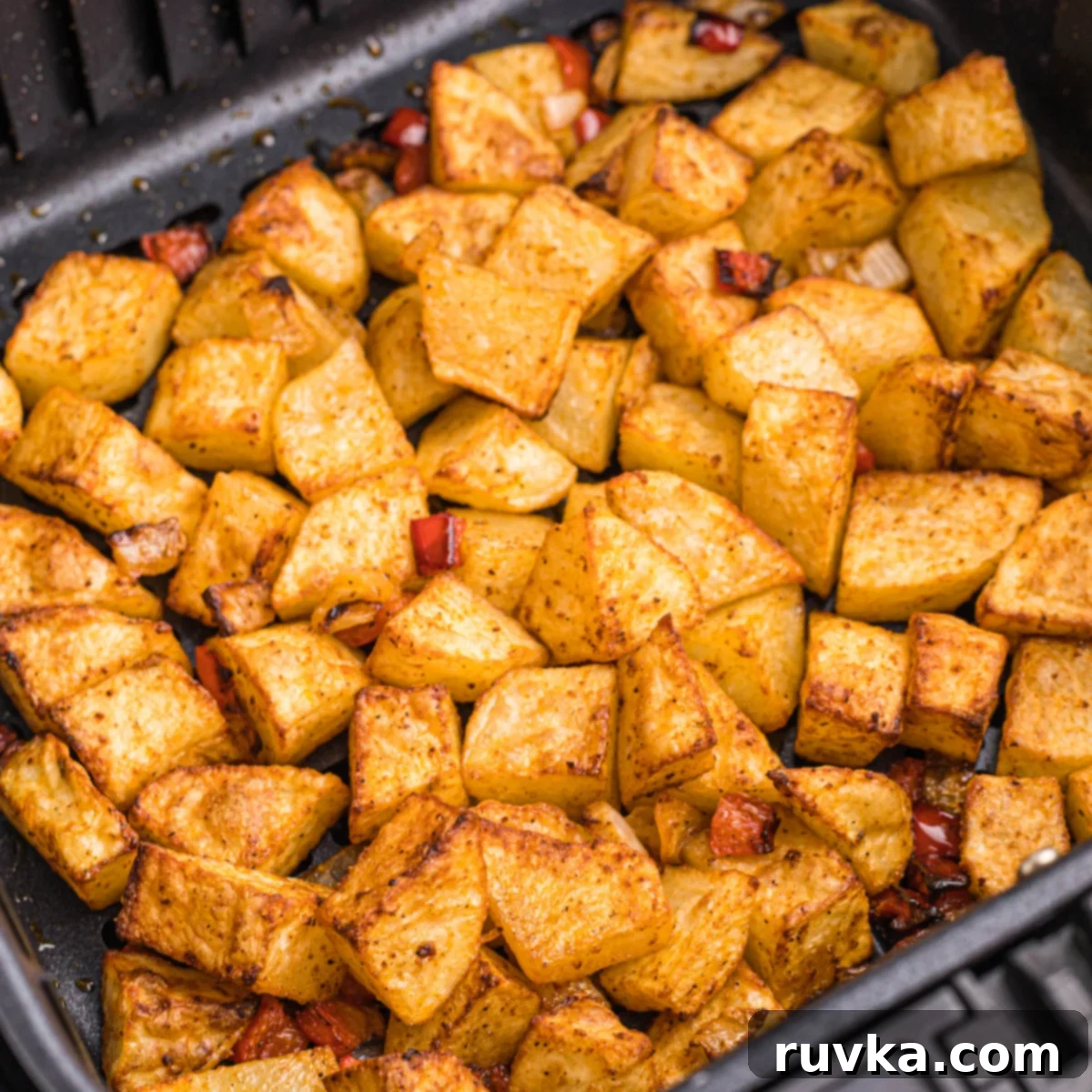 Crispy Air Fryer Home Fries 8 Golden brown, cooked home fries in the air fryer basket, steam rising, indicating they are hot and fresh.