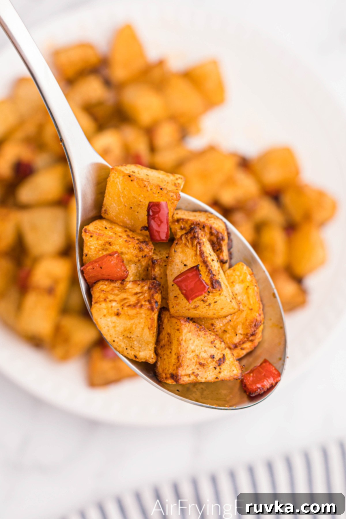 Crispy Air Fryer Home Fries 10 A spoonful of freshly made air fryer home fries, perfectly golden and crispy, ready to be enjoyed.