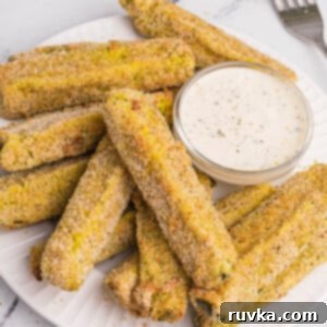 Crispy Air-Fried Dill Pickles 10 Overhead photo of crispy air fried dill pickles on a white plate with dipping sauce.