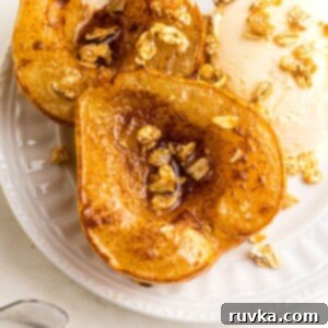 Golden Air Fryer Pears 11 Close up of pear halved and coated with melted butter and cinnamon brown sugar, then topped with granola and served with ice cream on a white plate