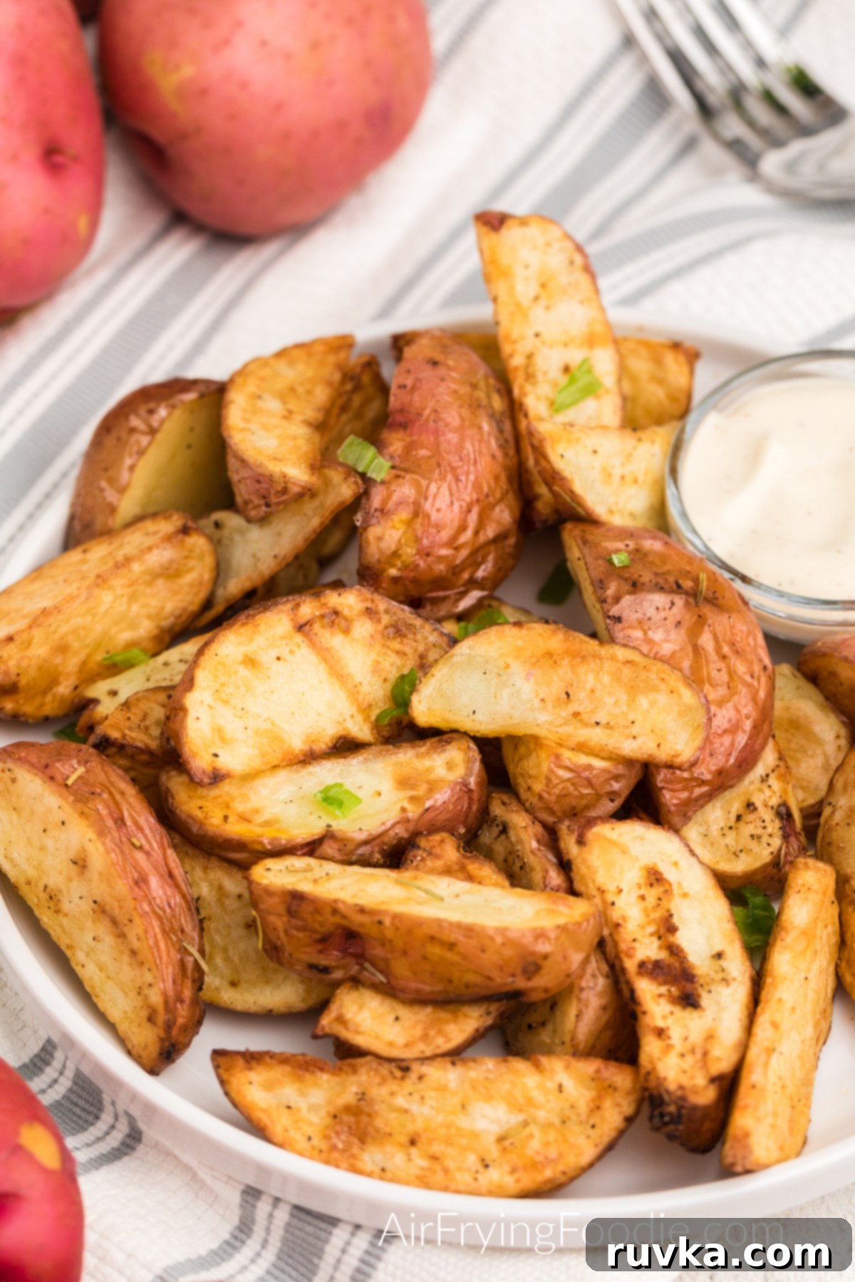 Crispy Air Fryer Red Potatoes 8 Seasoned air fried red potatoes on a plate with dipping sauce.
