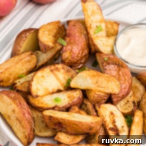 Crispy Air Fryer Red Potatoes 9 Seasoned air fried red potatoes on a white plate with dipping sauce, ready to eat.