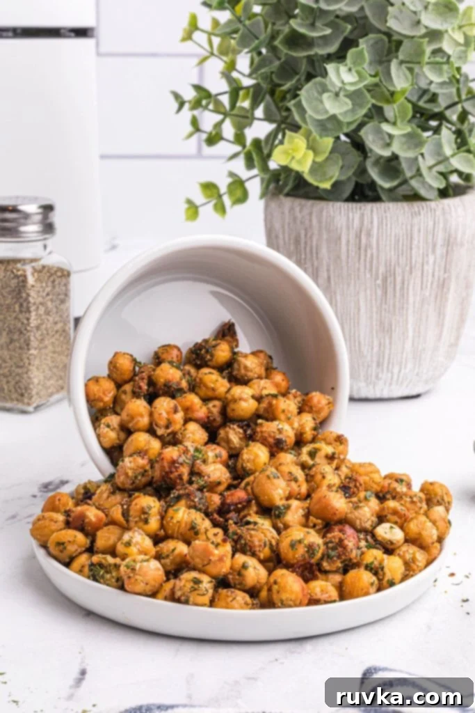 Crispy Air Fryer Chickpeas 2 Crispy chickpeas in a white bowl spilling onto a small white plate