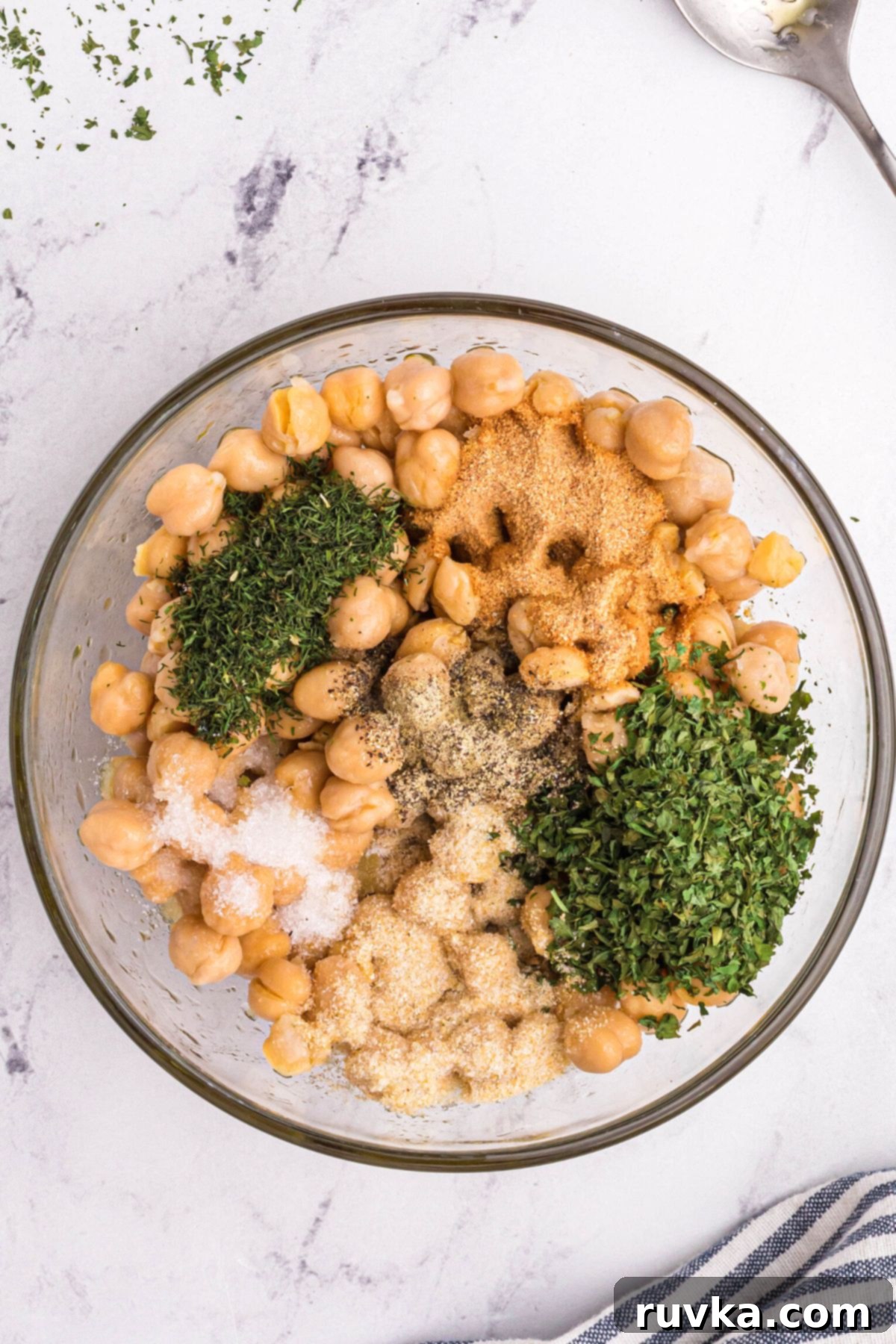 Crispy Air Fryer Chickpeas 5 Chickpeas mixed with seasonings in a clear glass bowl