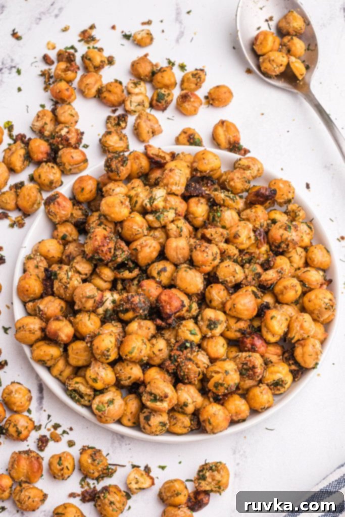 Crispy Air Fryer Chickpeas 8 golden brown crispy chickpeas after being cooked in the air fryer basket on a white marble table with a serving spoon