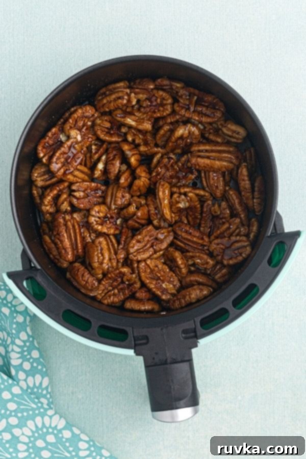 Irresistible Air Fryer Spiced Pecans 4 Spiced pecans before being cooked, marinating in the air fryer basket.