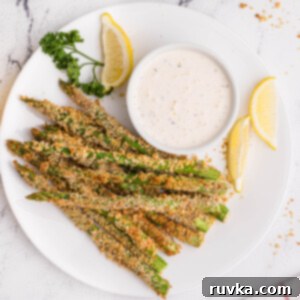 Crispy Air-Fried Asparagus Sticks 7 Plated air fried asparagus fries with lemon wedges and dipping sauce.