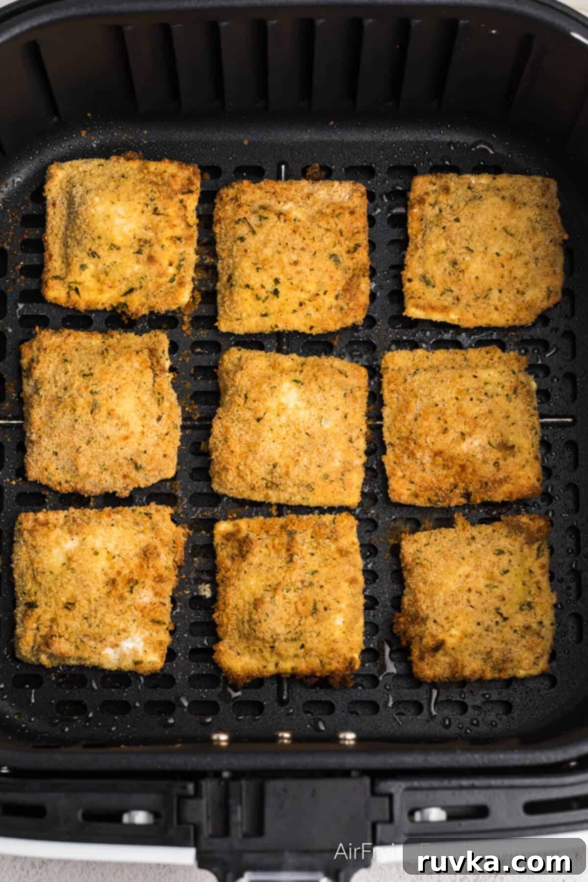 Golden Air-Fried Ravioli Bites 8 Fried ravioli in air fryer basket, ready to serve.