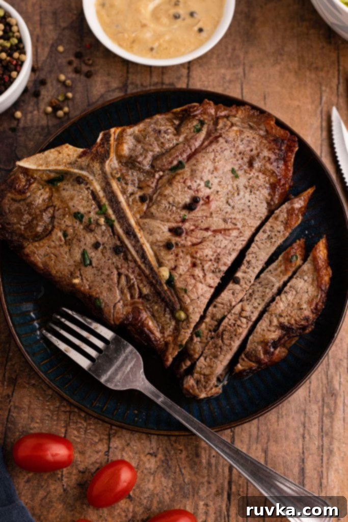 Restaurant-Quality Air Fryer T-Bone 8 Juicy T-Bone steak cooked in the air fryer, served on a blue plate with a fork and knife.