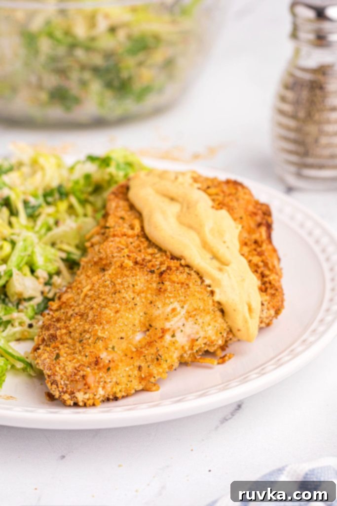 Crispy Air Fryer Chicken Cordon Bleu 11 golden crispy chicken served with Dijon mustard and salad on a white plate