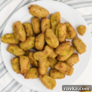 Wholesome Crispy Air Fryer Veggie Tots 6 Overhead photo of broccoli and cheese veggie tots on a white plate, ready to serve.