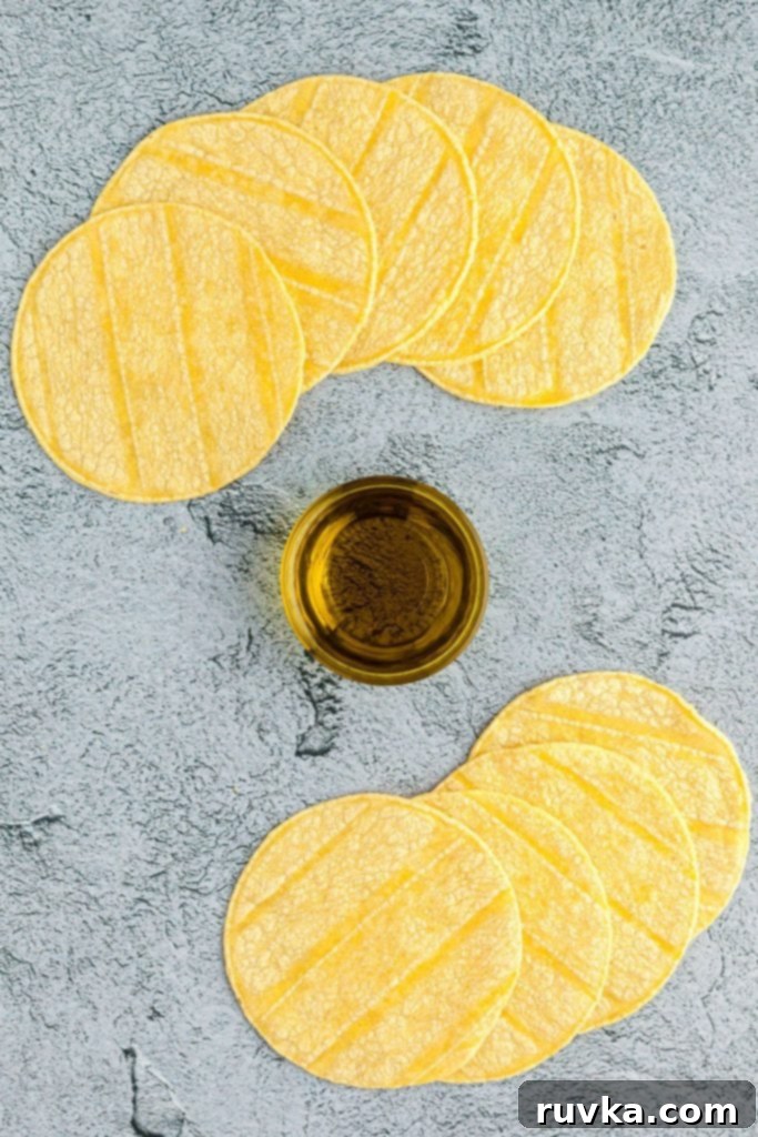 Easy Crispy Air Fryer Taco Shells 3 Tortillas and olive oil on a gray table