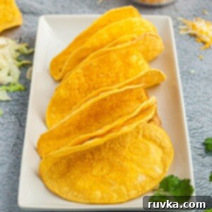 Easy Crispy Air Fryer Taco Shells 9 golden crispy shells on a white plate