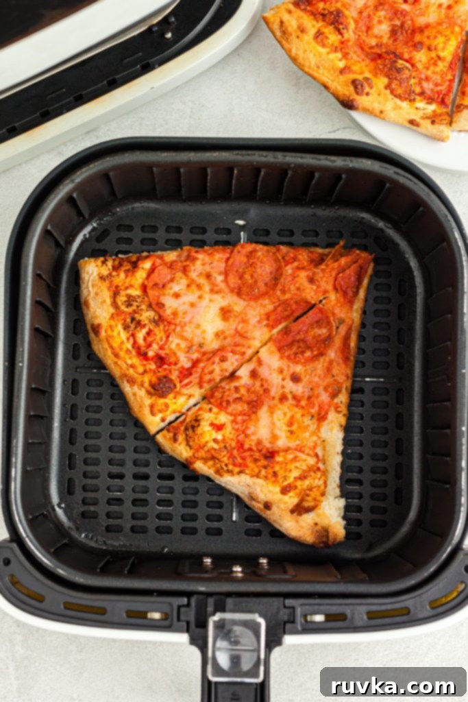 Air Fryer Magic: Crispy Leftover Pizza Every Time 4 uncooked pizza slices in the air fryer basket