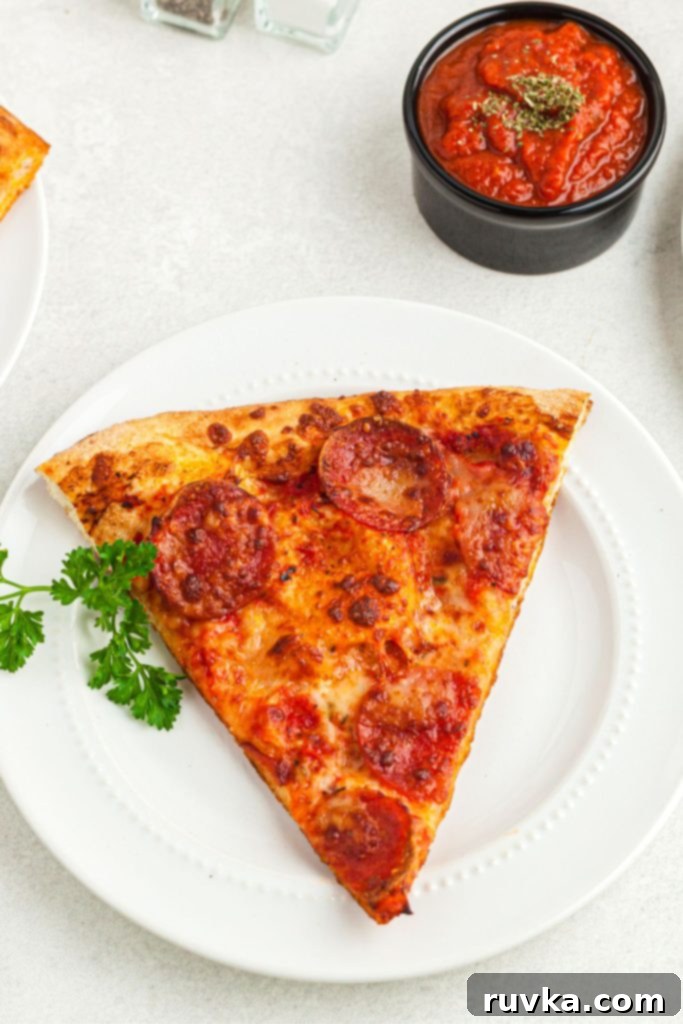 Air Fryer Magic: Crispy Leftover Pizza Every Time 6 Golden pizza slice on a white plate