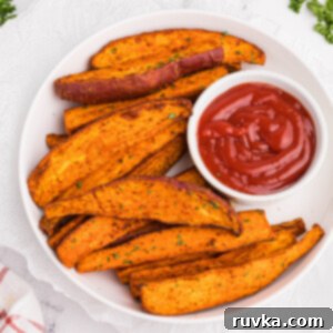 Crave-Worthy Crispy Air Fryer Sweet Potato Wedges 11 Overhead photo of sweet potato wedges made in the air fryer and served with a side of ketchup.
