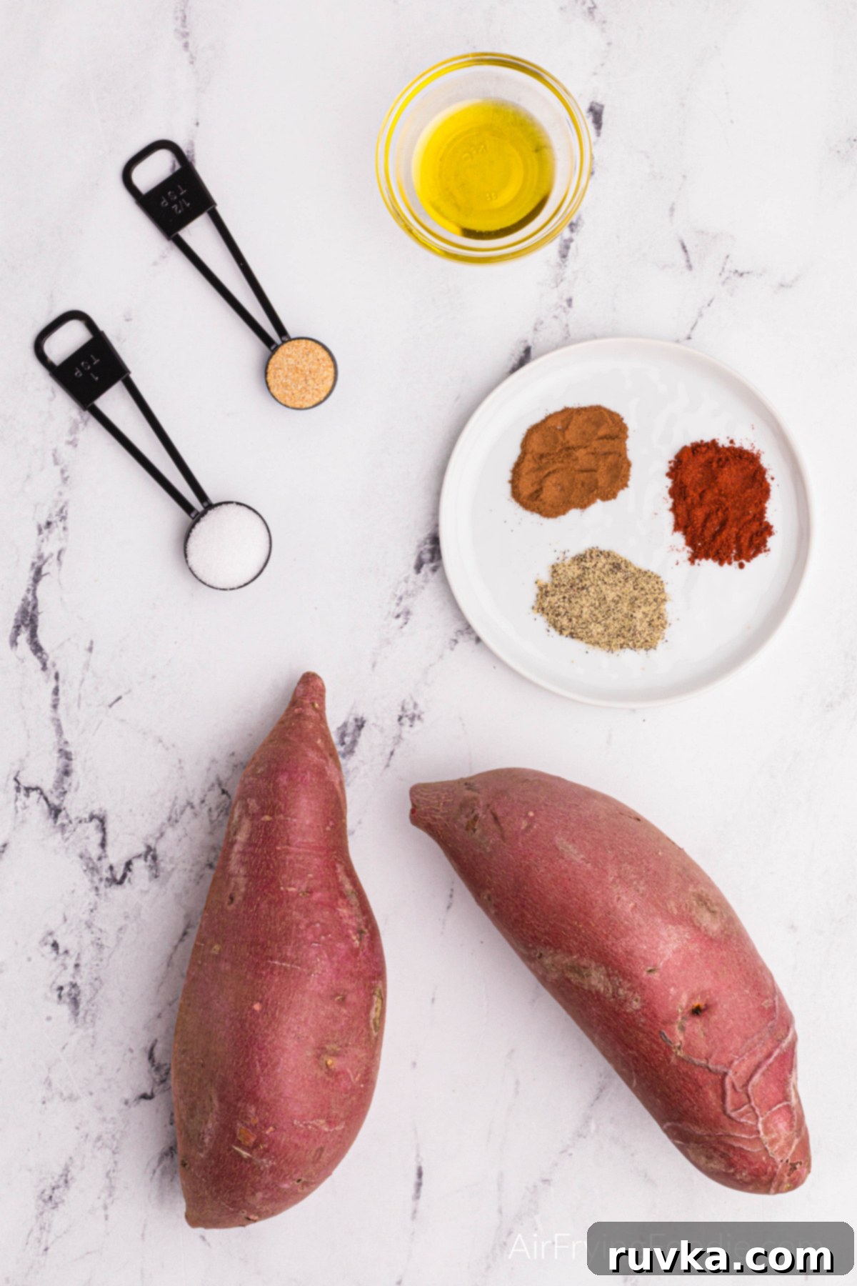 Crave-Worthy Crispy Air Fryer Sweet Potato Wedges 3 Olive oil in a bowl with the seasoning on a white plate & whole sweet potatoes.
