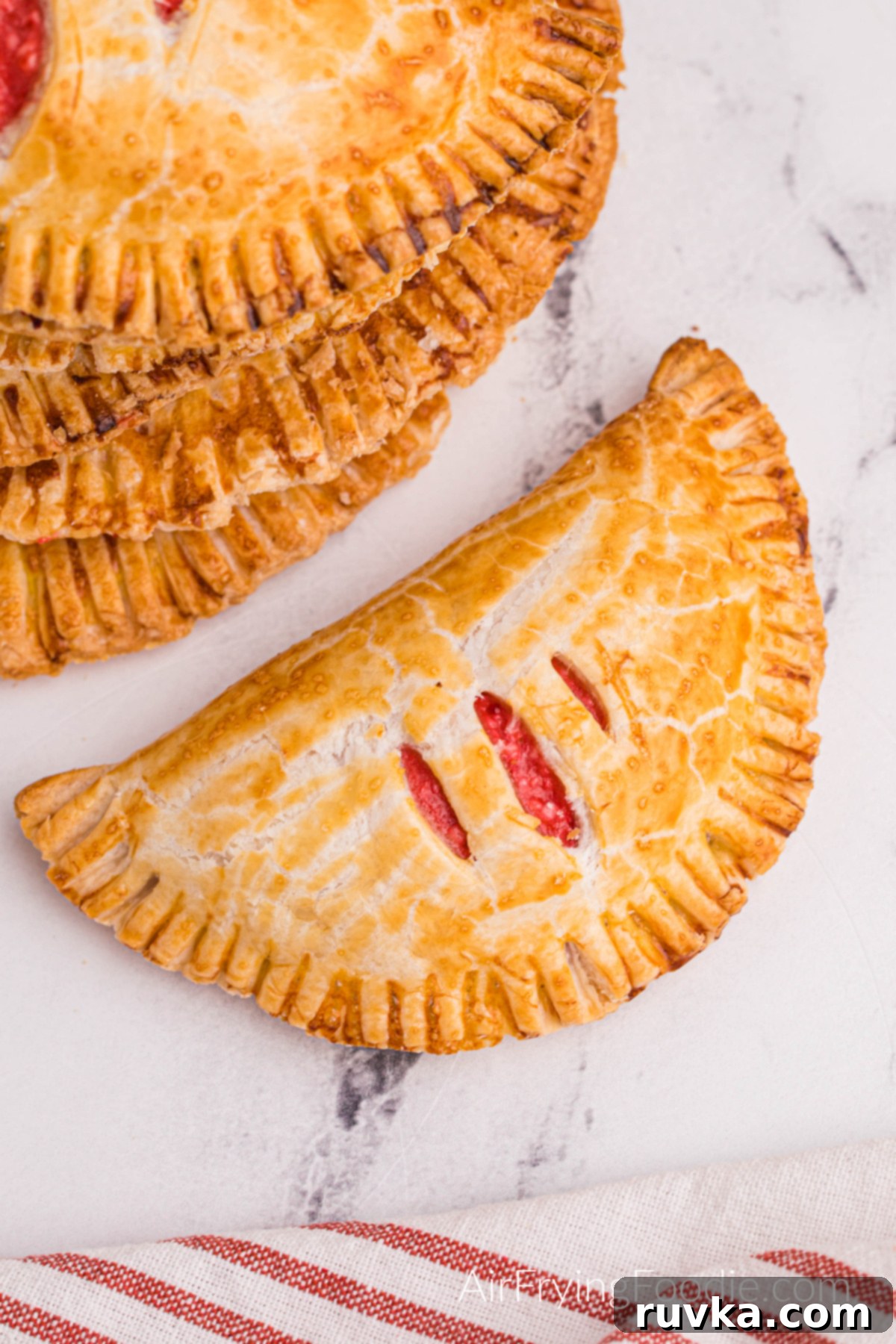 Air Fried Cherry Cream Cheese Pies 2 Overhead photo of golden-brown cream cheese cherry pies made in the air fryer, beautifully arranged and ready to serve.