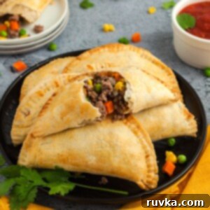 Crispy Air Fryer Empanadas 12 Golden empanadas filled with ground beef and vegetables on a black plate