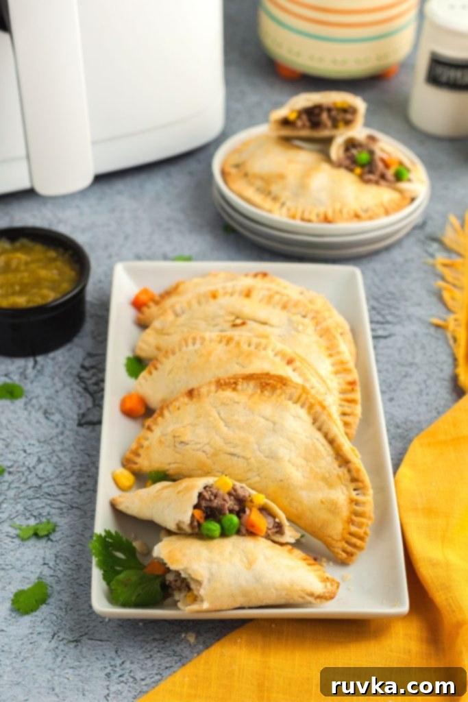 Crispy Air Fryer Empanadas 10 Long square plate with empanadas served on it with salsa and linen on table