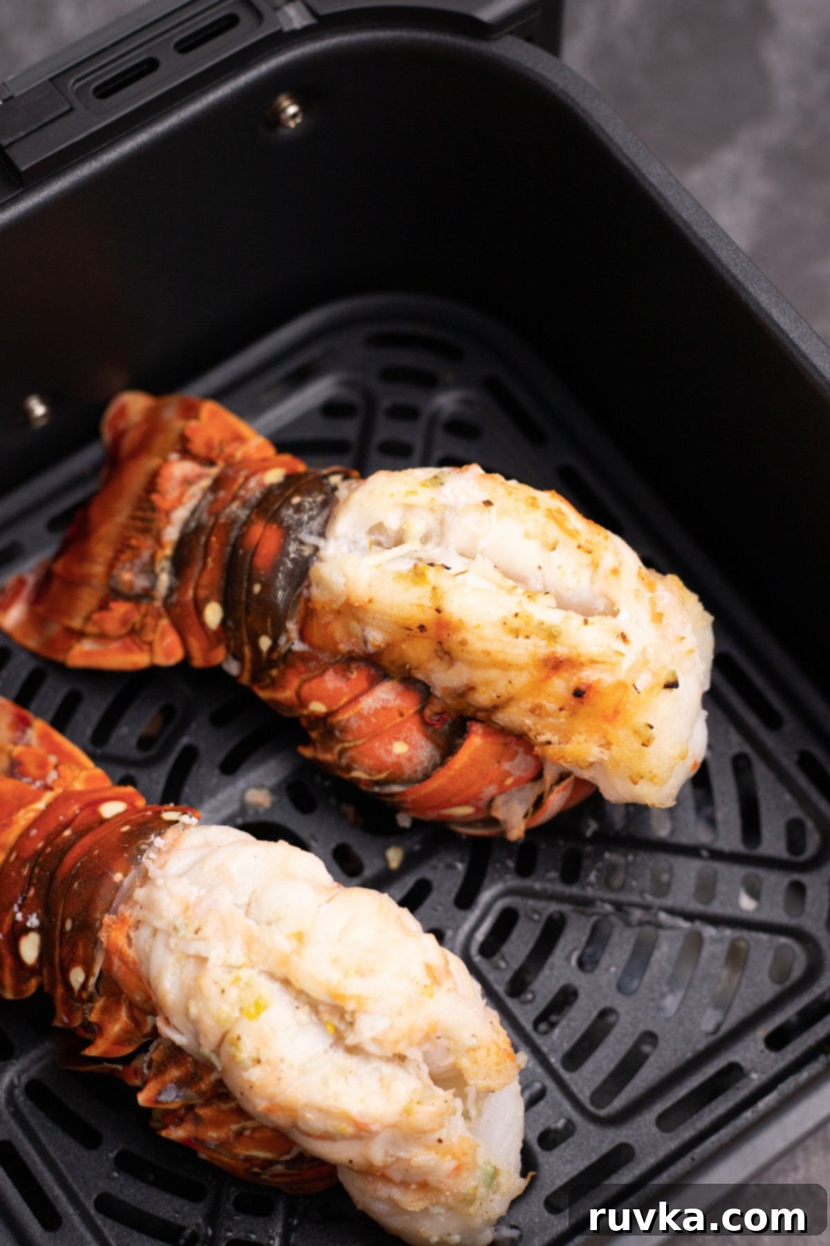 Crispy Air-Fried Lobster Tails 7 Two red/orange lobster tails in the air fryer basket, after being cooked. Perfectly cooked, vibrant red and white air-fried lobster tails resting in the air fryer basket, steam rising, indicating fresh doneness.