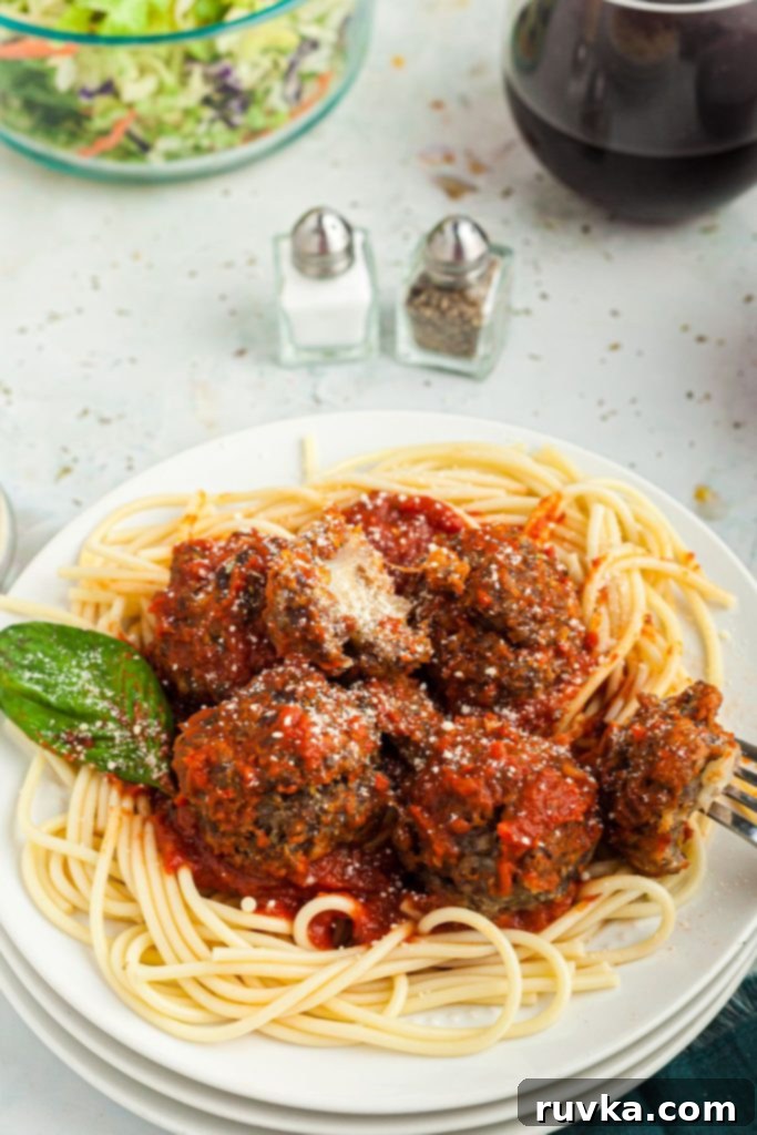 Crispy Air Fryer Cheese Stuffed Meatballs 2 Air Fryer Cheese Stuffed Meatballs served over pasta on a marble table.
