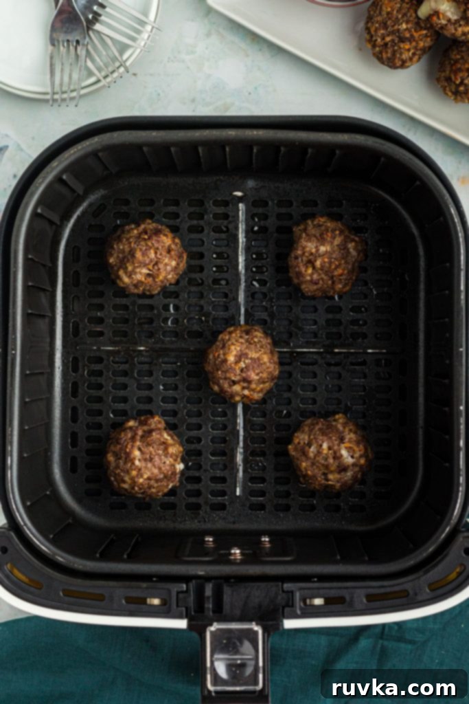 Crispy Air Fryer Cheese Stuffed Meatballs 7 Cooked meatballs in the air fryer basket.