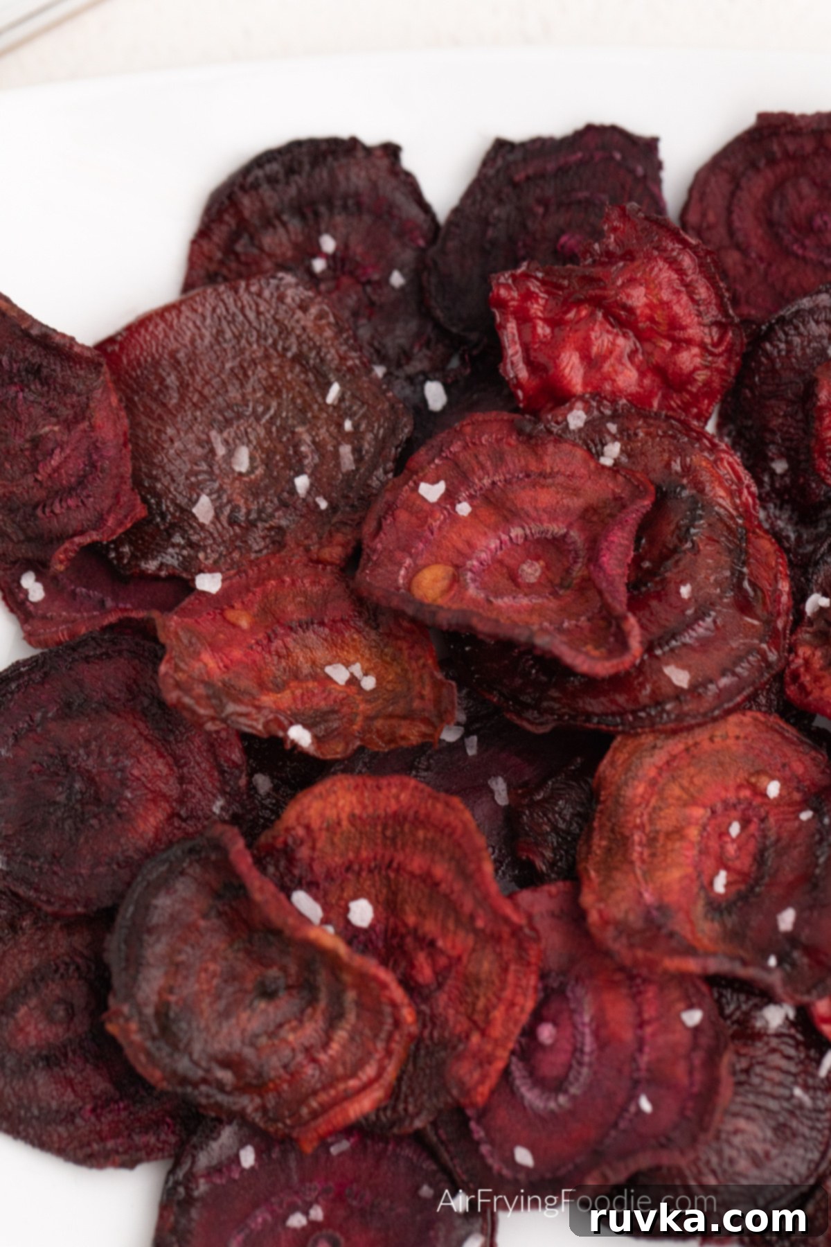 Crispy Air Fryer Beet Chips 9 Close up photos of air fried beet chips on a white plate and topped with kosher salt.