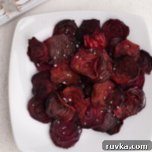 Crispy Air Fryer Beet Chips 10 Overhead shot pf beet chips made in the air fryer, served on a whote plate, and topped with kosher salt.