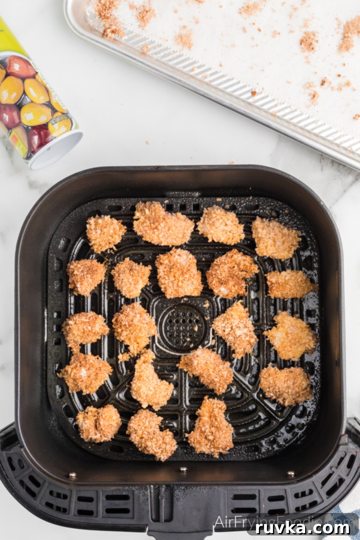 Air-Fried Chicken Poppers 6 Perfectly breaded and seasoned popcorn chicken arranged in a single layer in the air fryer basket, ready for cooking.