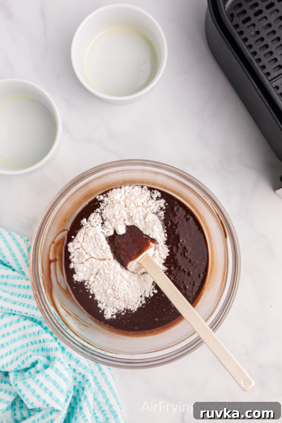 Easy Air Fryer Molten Chocolate Cakes 7 Flour being added to the chocolate mixture.