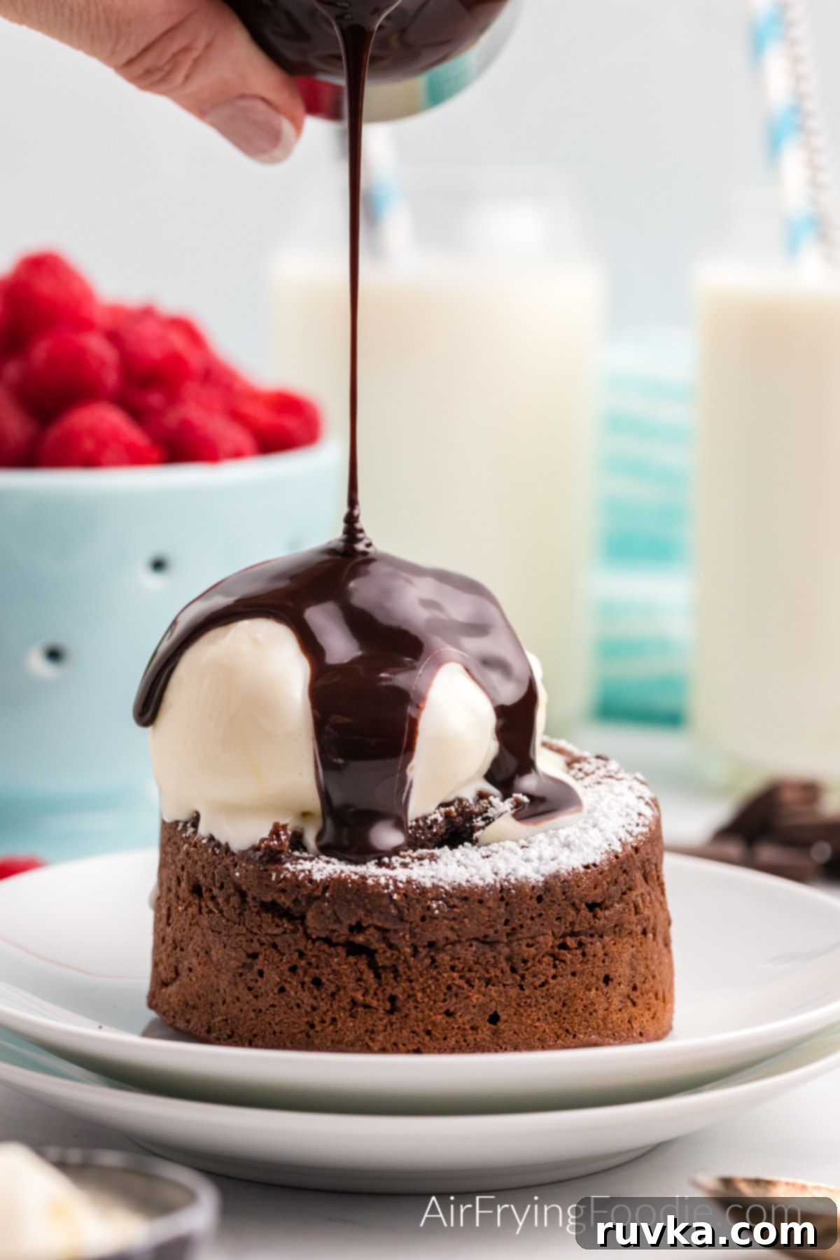 Easy Air Fryer Molten Chocolate Cakes 9 Air Fryer Lava cake topped with confectioner's sugar, ice cream, and chocolate sauce.