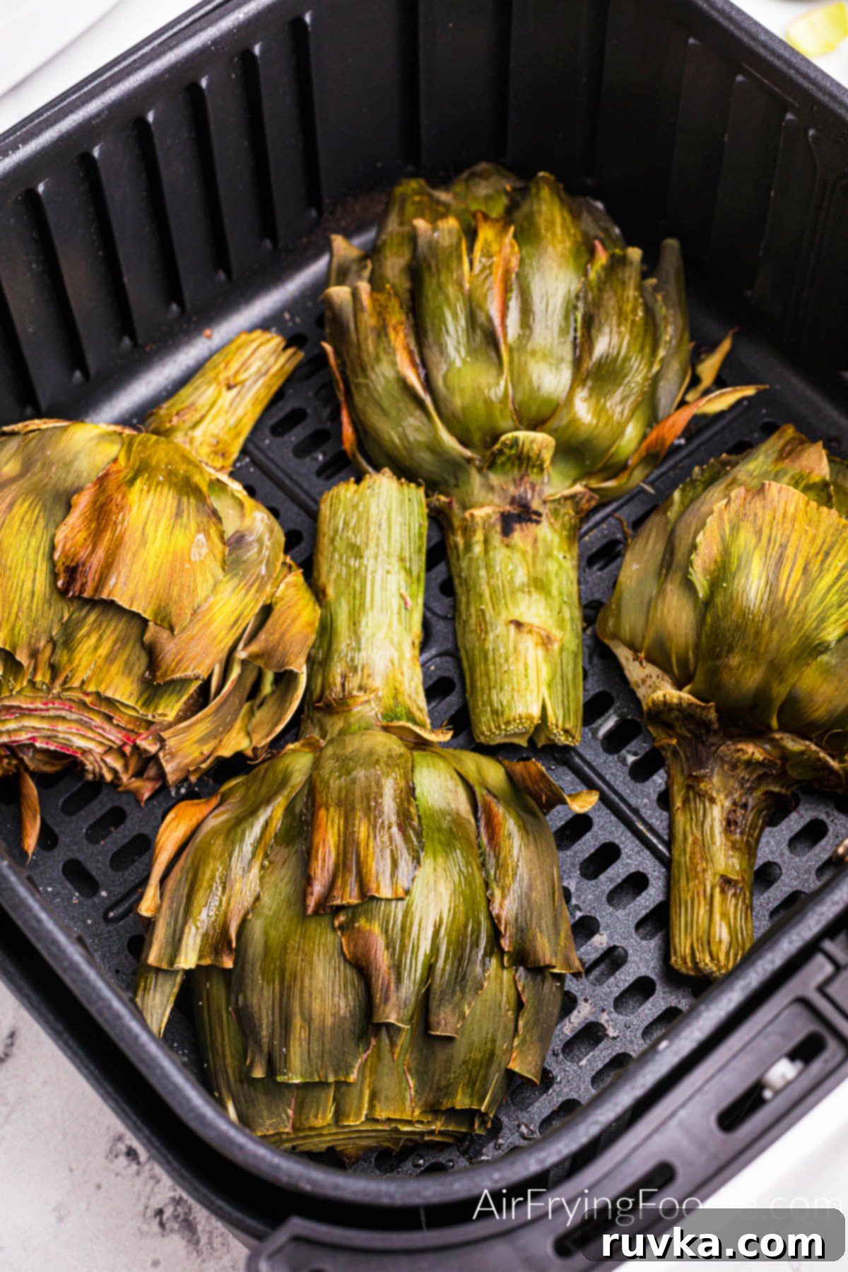 Air-Fried Artichoke Perfection 2 Cooked artichoke in the basket of the air fryer.