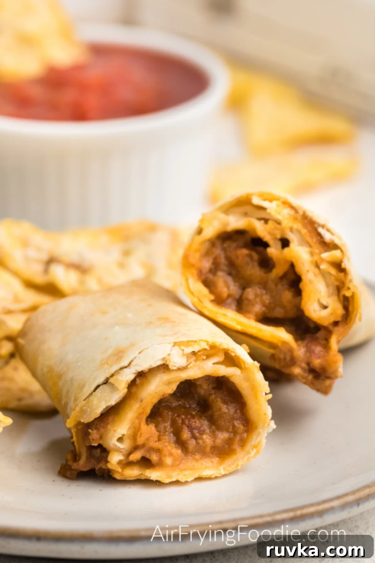 Perfectly Crispy Air Fried Frozen Burritos 2 Air fried frozen burrito fully cooked and served on a plate with a side of tortilla chips, showcasing its golden-brown crispiness and inviting texture.
