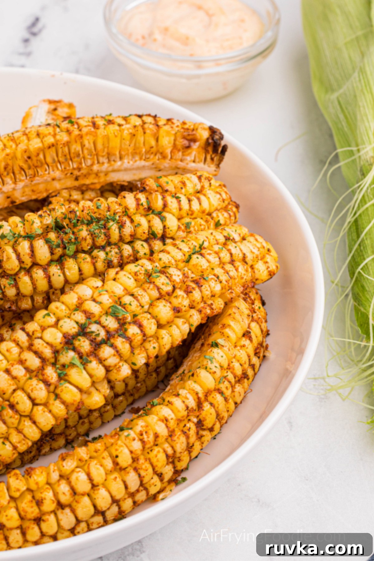 Crispy Air Fried Corn Ribs 2 Air fryer corn ribs on a plate, garnished with fresh parsley and ready to eat.