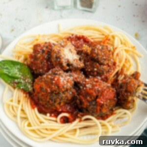 Quick Air Fryer Back to School Dinners 6 Cheese stuffed meatballs served over pasta on a white plate, perfect for an Air Fryer meal.
