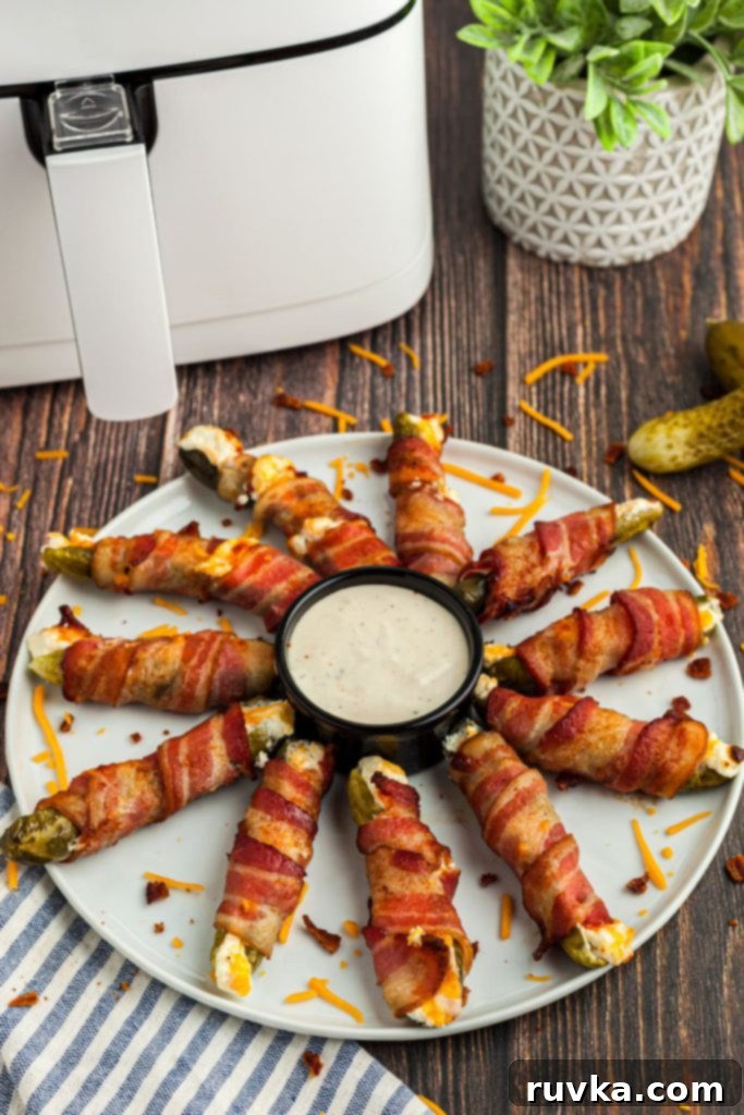 Air-Fried Pickle Bites 9 White round plate with pickle poppers around the dip on a wood table