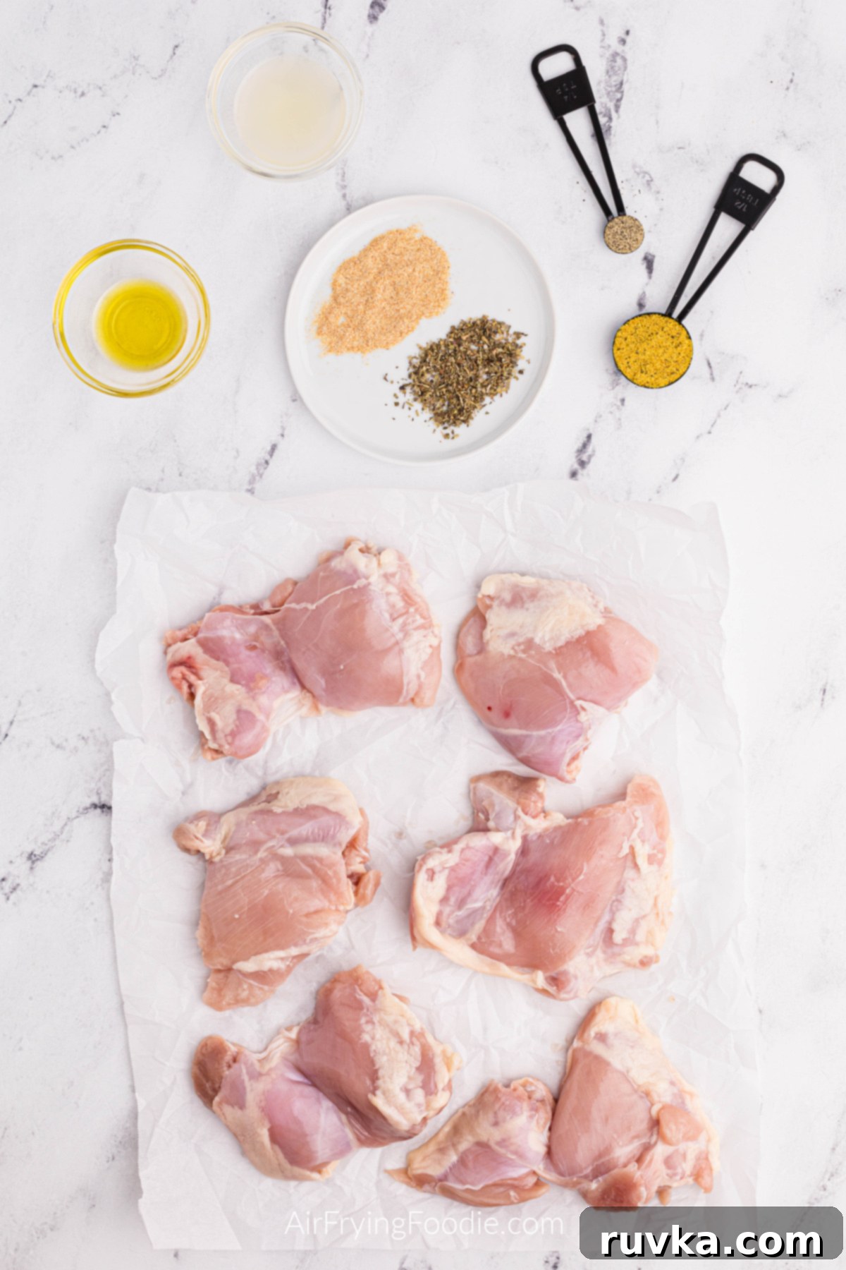 Crispy Air Fryer Lemon Pepper Chicken Thighs 3 Selection of ingredients for Lemon Pepper Chicken Thighs: chicken thighs, lemon pepper seasoning, Italian seasoning, garlic powder, black pepper, olive oil, and fresh lemons.