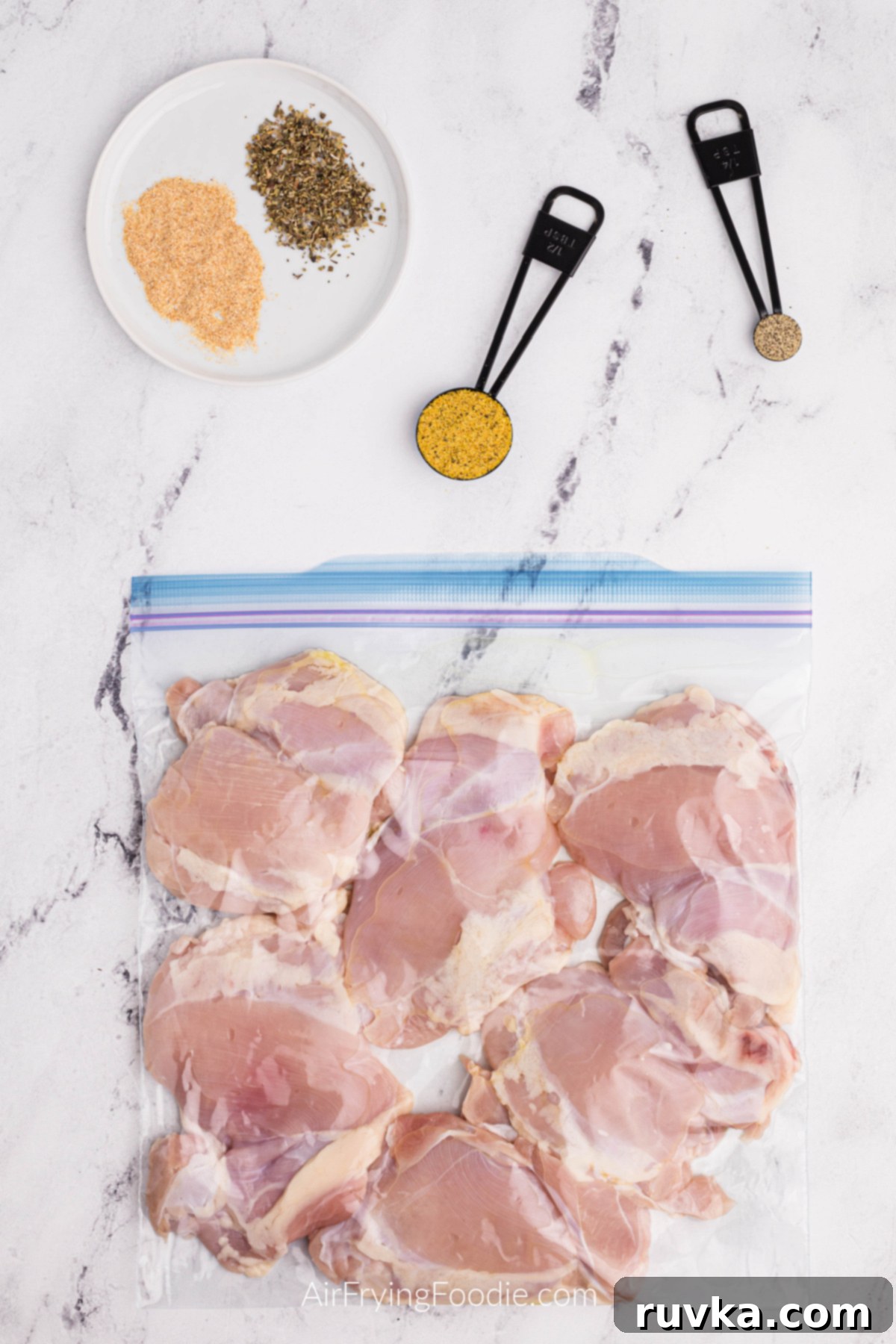 Crispy Air Fryer Lemon Pepper Chicken Thighs 4 Chicken thighs placed in a plastic resealable bag with olive oil and fresh lemon juice, ready for seasoning.